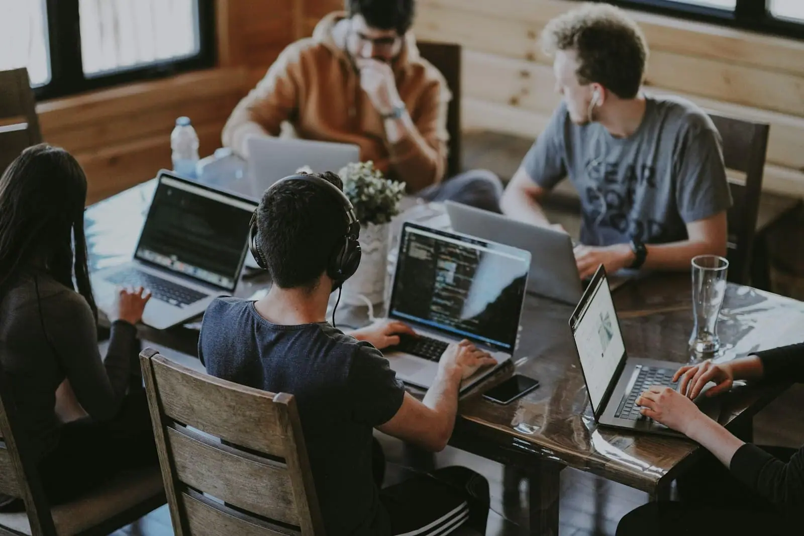 Engineers collaborating at laptops around a shared table